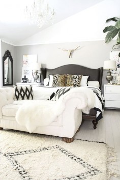 neutral but bold and beautiful bedroom with Beni Ourain rug, leather studded bed, brass longhorn skull, and black and white accents- @Cuckoo4Design