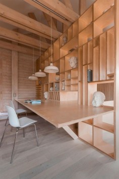 Plywood artist's studio by Ruetemple combines areas for storage, seating and sleeping.