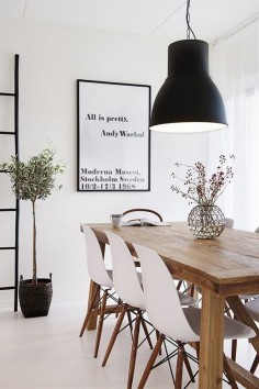 Scandinavian inspired apartment dining room with oversized industrial pendant light. Black and white space is softened with the addition of the timber table