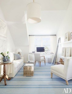 The master suite’s inviting sitting area extends the home’s palette of pale neutrals accented by hits of blue.