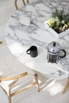 The stunning white Wishbone chairs, oak & limewashed floors, paired with a dramatic white marble table top give coastal styling a luxury take.