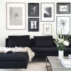 black chaise lounge, grey stone coffee table and a wall of frames