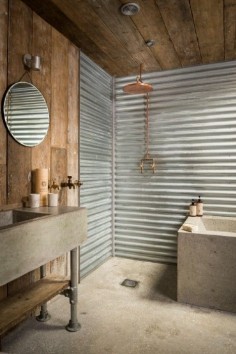 Cabin | Corrugated tin bathroom is separated by a sliding steel barn door
