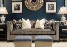 Dark blue walls, black and white accents, Gray couch.