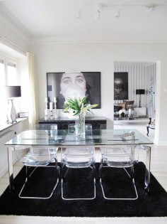 Glass dining table and acrylic chairs with black & white design elements