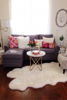 In this room the pop of bright color from 2 pillows is accentuated by the grey and white colors surrounding them. White is a bright color too. In this case it is positioned on every surface in this room. The white coffee table (from HomeGoods) helps visually in making this vignette feel complete and anchors the space. Sponsored by HomeGoods