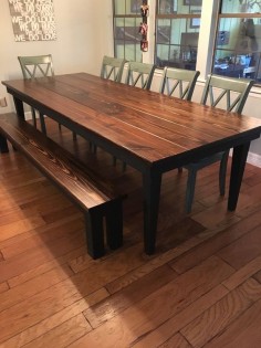 James+James 9' x42" Farmhouse Table with a traditional top stained in Vintage Dark Walnut and a painted black base and tapered legs. Pictured with matching Farmhouse Bench.  Large customizable rustic dining table green dining chairs hardwood floor solid wood furniture