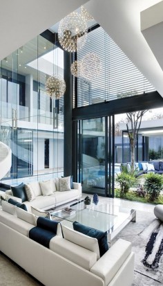 So many windows, so wonderful! What awesome lighting and tables and furniture as a whole. Good color theme. Contemporary living room.
