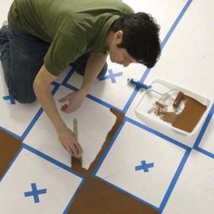 starting to paint the dark squares in a checkerboard pattern on a wood floor
