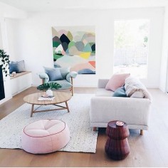 This painting in the background sets the pastel color palette for this feminine living room space.