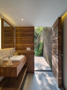 Unique bathroom design. Crisp modern shapes, minimal fixtures, warm tones from the natural materials and clean flooring style that leads out into the garden space.
