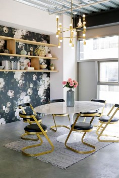 Feminine workspace with floral wallpaper, a gold chandelier and gold chairs